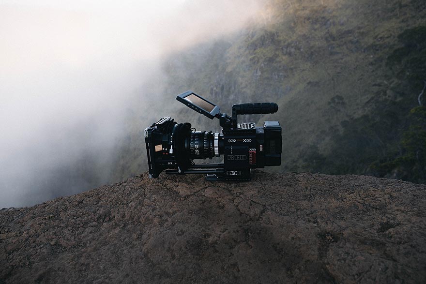 A camera on a rock with mountains in background