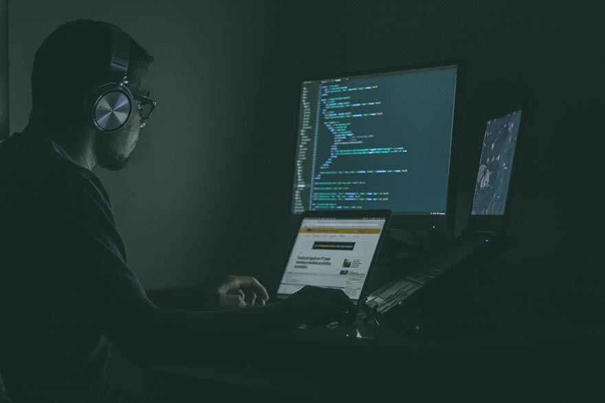 A young man working on computer in dark